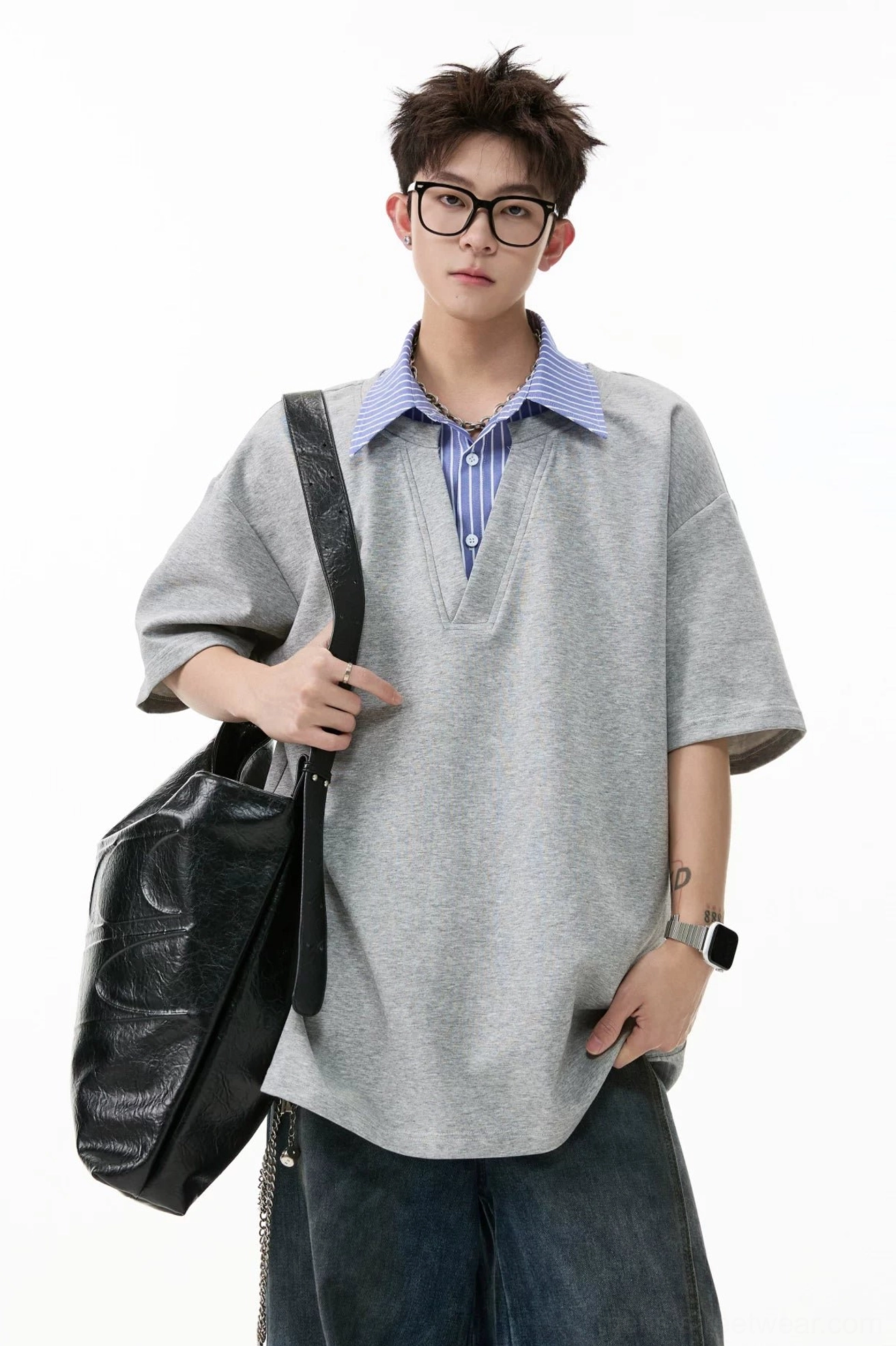 Gray oversized layered V-placket polo tee with purple-blue striped collar styled with dark washed denim and shoulder bag