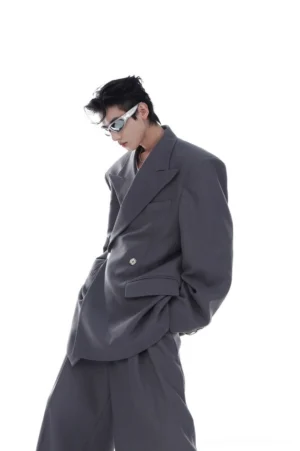 Side view of gray loose-fit double-breasted blazer with peak lapels and oversized tailored silhouette