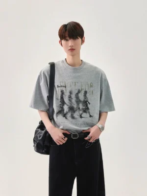Heather gray oversized graphic T-shirt featuring a blurred retro marching figure print, relaxed crew neck, and Korean streetwear crossbody styling