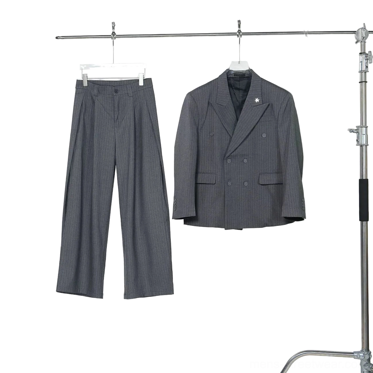 Gray pinstripe double-breasted blazer and high-waisted wide-leg trousers displayed separately on studio clothing rack