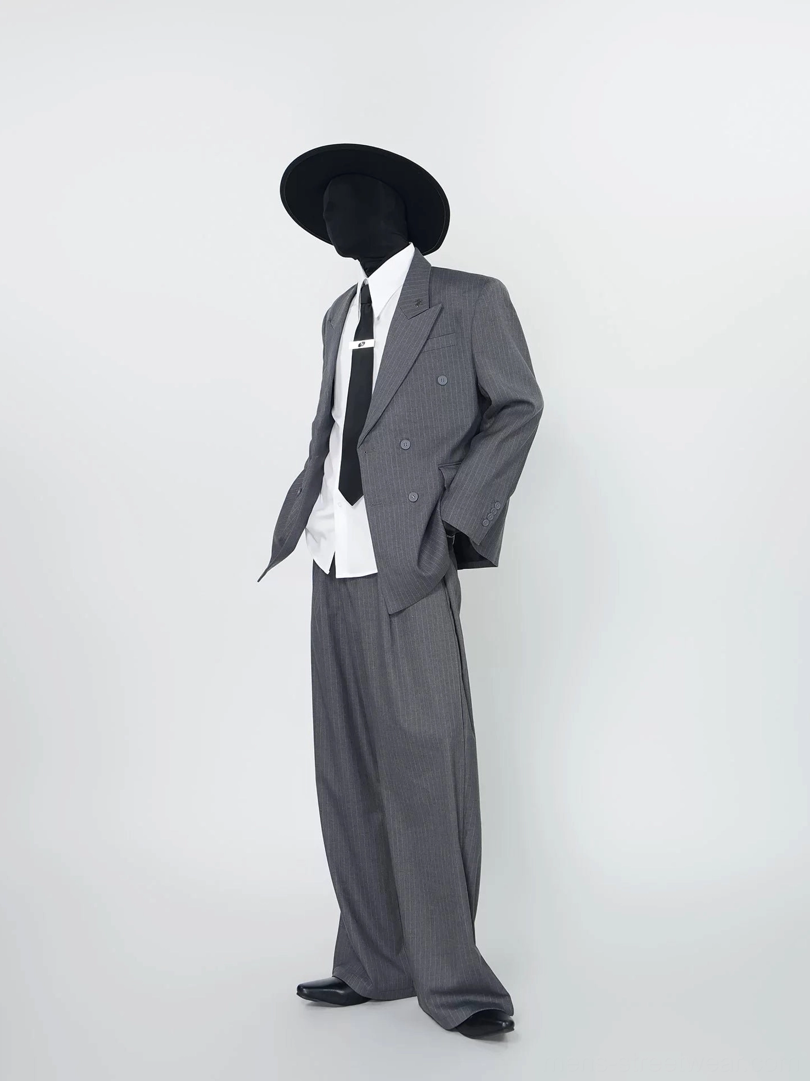 Gray pinstripe double-breasted blazer and wide-leg trouser set styled with white shirt black tie and cowboy hat left full body view
