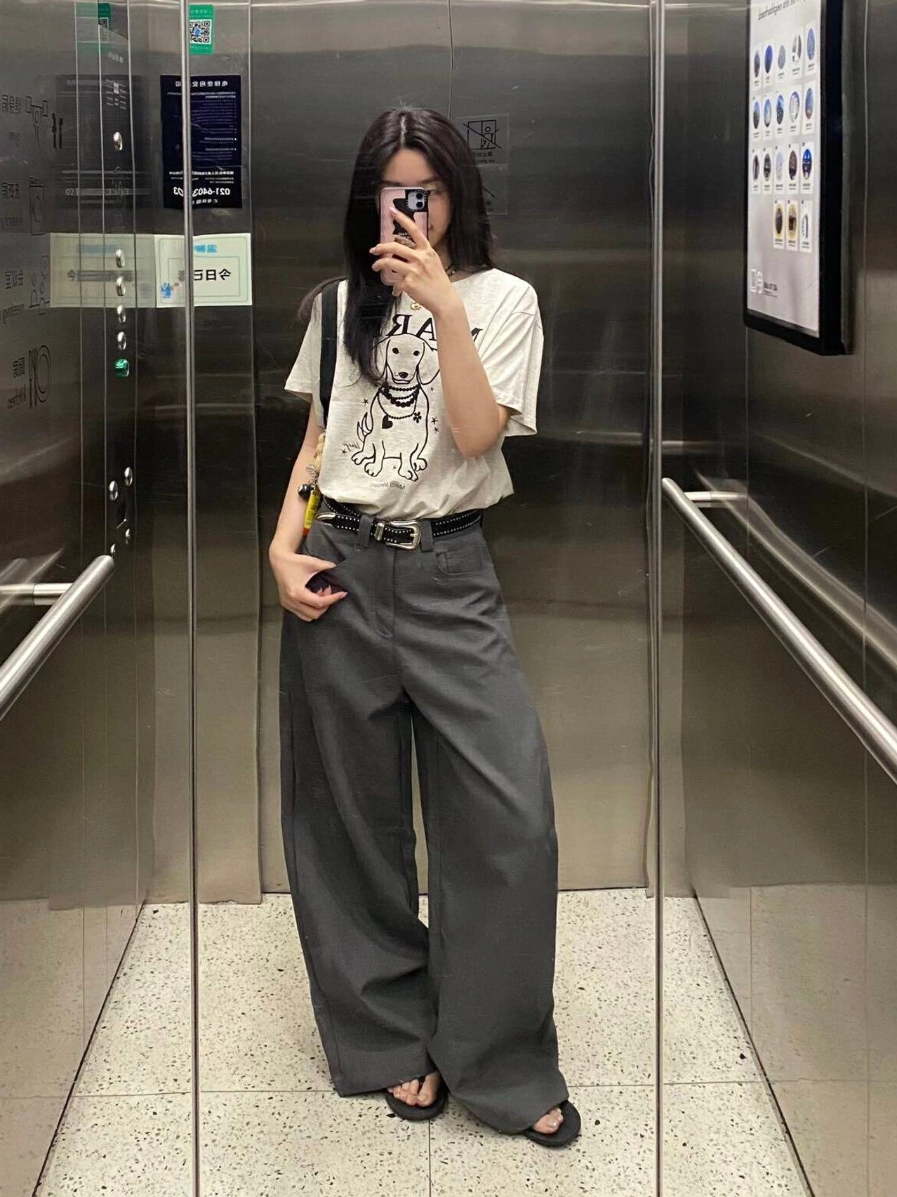 Gray pleated wide-leg trousers styled with a casual printed shirt and sandals in a modern high-waisted everyday outfit