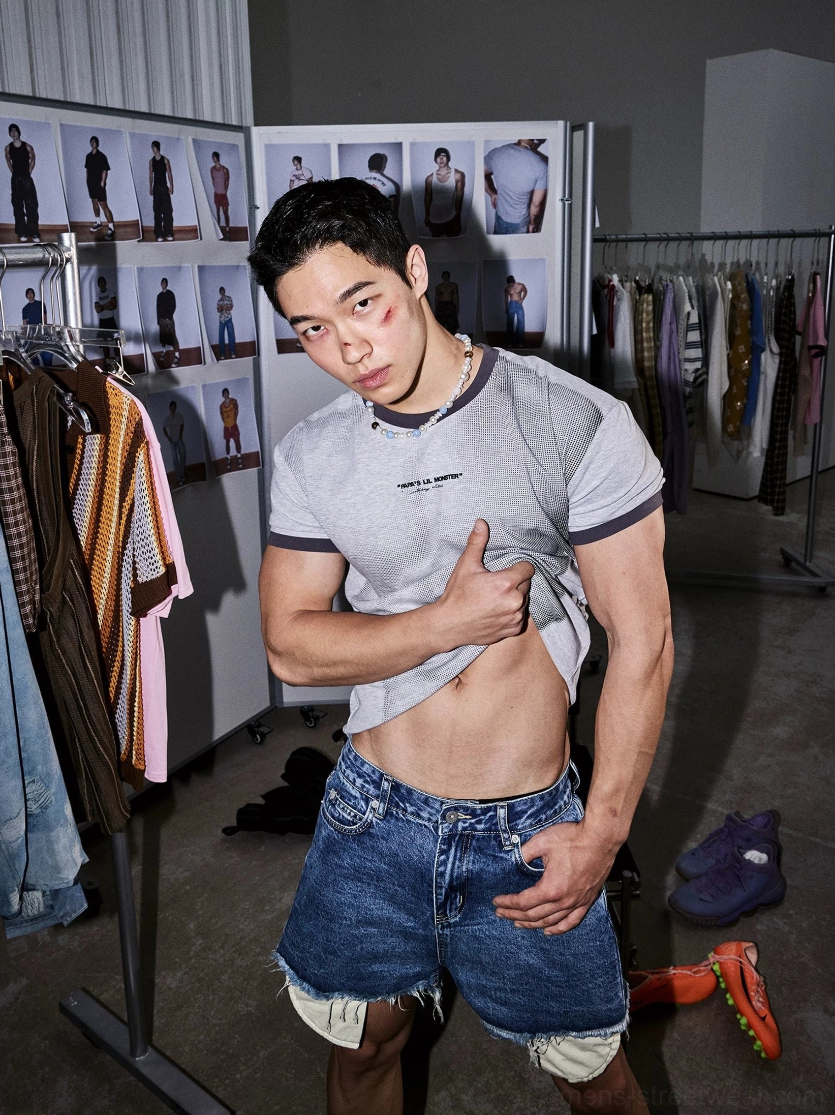 Low angle view of gray ringer T-shirt with dark contrast trim styled with raw hem denim shorts