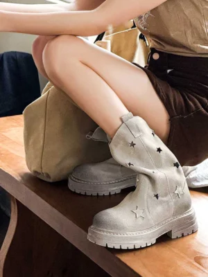 Gray perforated star platform boots worn in a casual indoor setting, showing the distressed nubuck texture and chunky streetwear sole