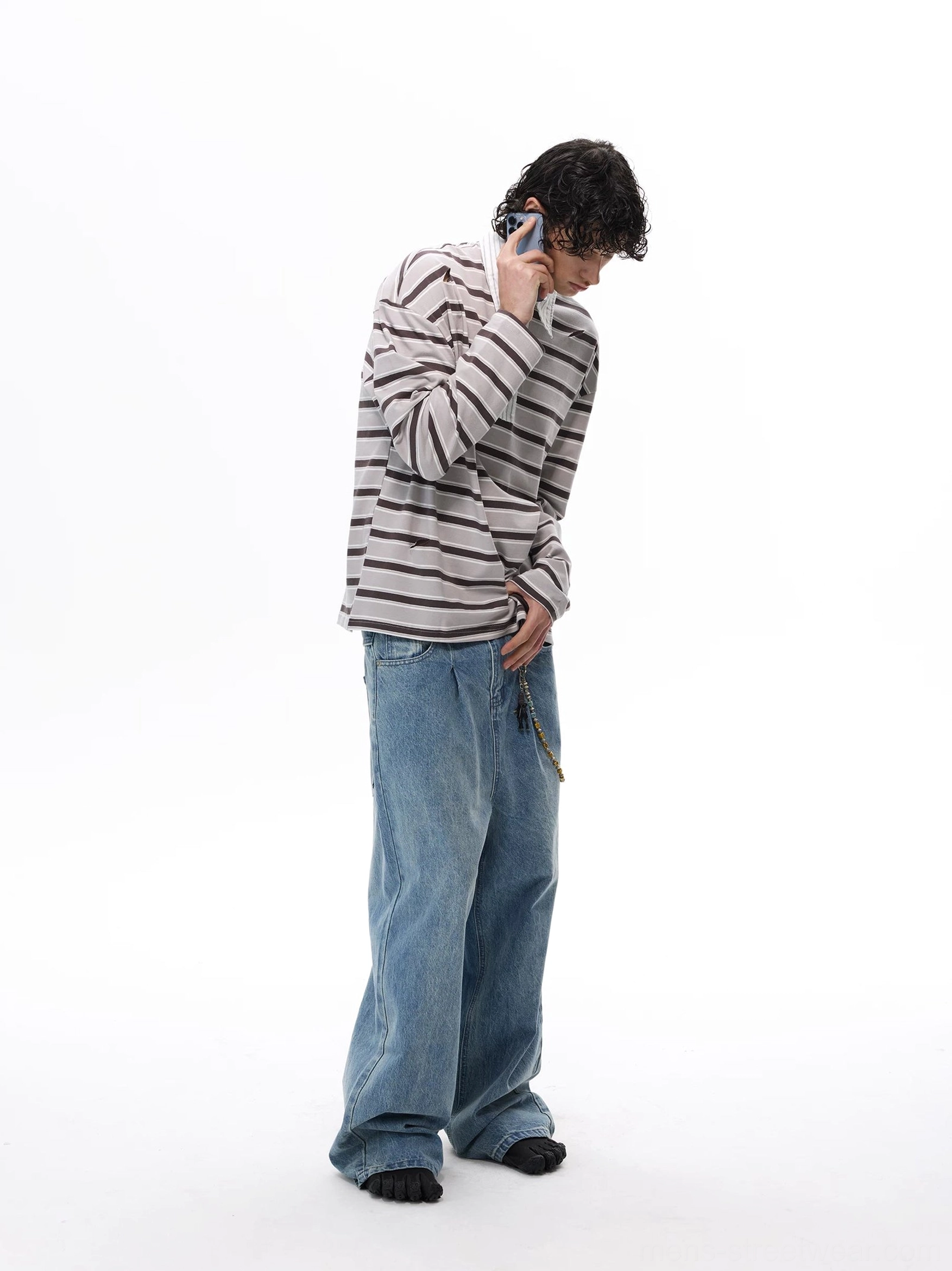 Gray striped long-sleeve rugby shirt with half-button front and relaxed Korean streetwear silhouette worn with baggy denim