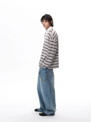 Gray horizontal striped rugby polo shirt with loose oversized fit, long sleeves, and white contrast collar styled with baggy jeans