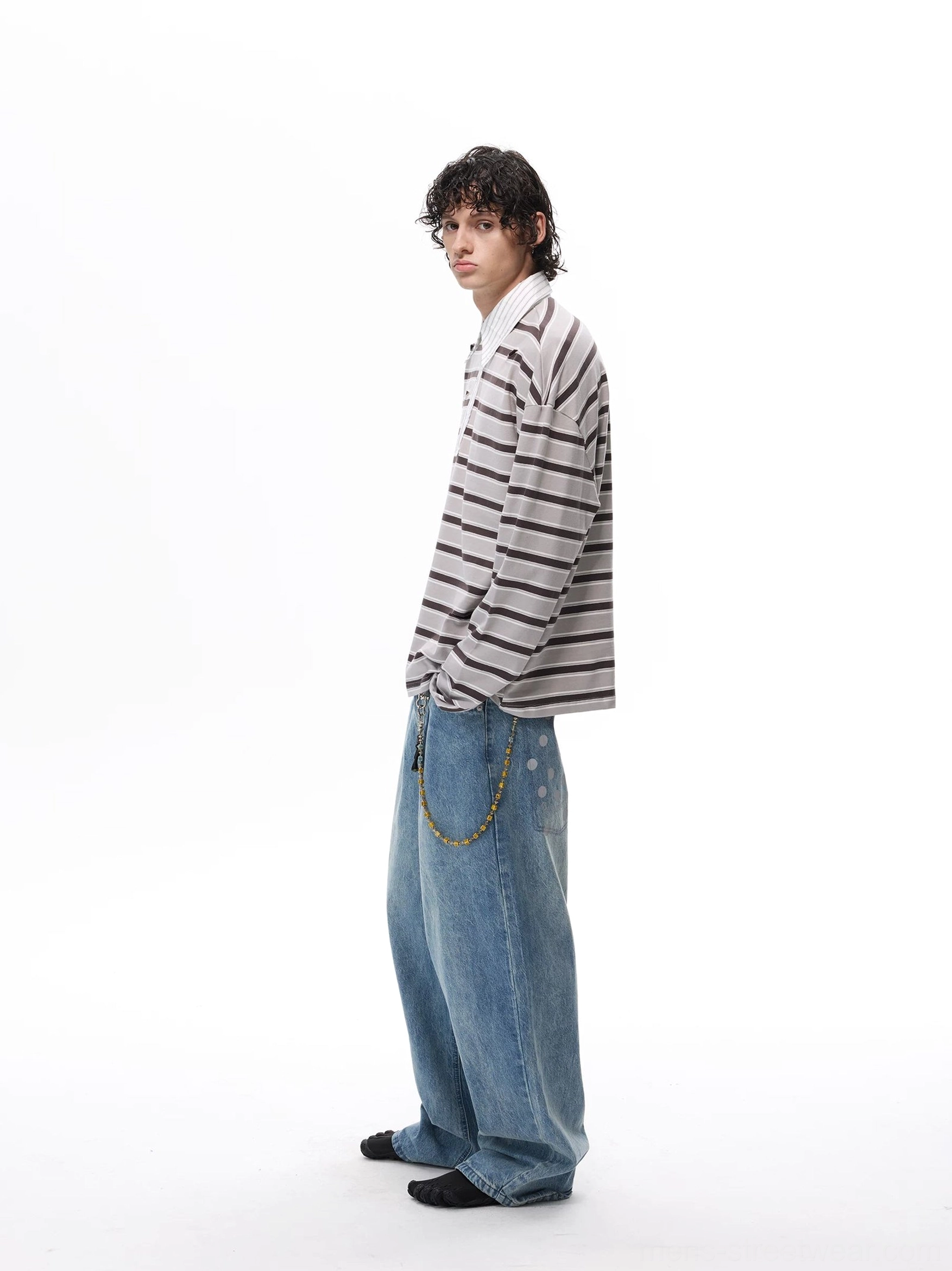 Gray horizontal striped rugby polo shirt with loose oversized fit, long sleeves, and white contrast collar styled with baggy jeans