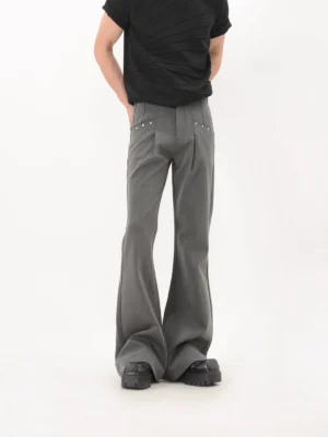 Rear three quarter view of gray studded flare trousers for men styled with a black ribbed tee and platform leather shoes in a Korean streetwear outfit
