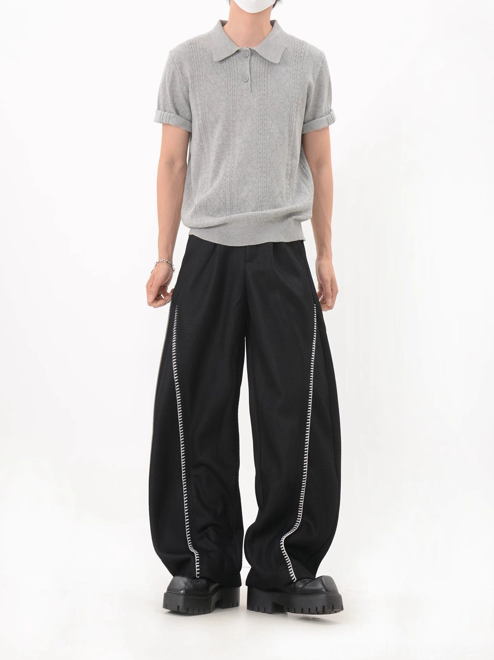 Rear three-quarter view of gray textured knit polo shirt with rolled short sleeves and clean ribbed hem