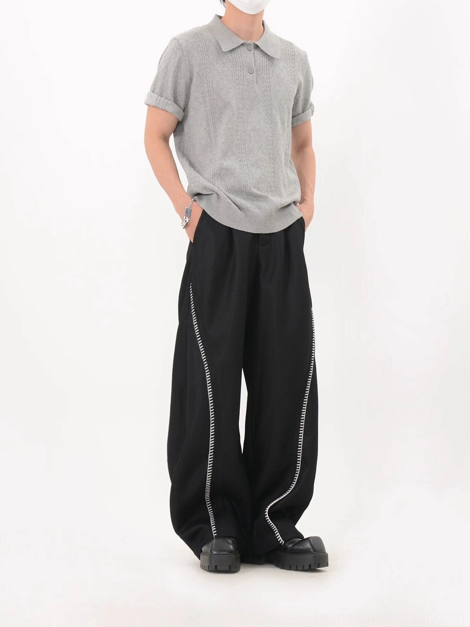 Gray textured lattice knit polo shirt with rolled cuffs and relaxed fit paired with black wide-leg streetwear pants