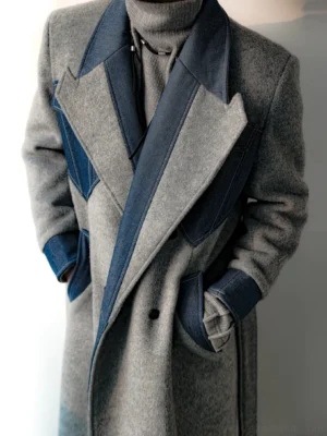 Close-up three-quarter view of gray two-tone wool blend double-breasted overcoat with navy contrast peak lapels, pockets, and cuff panels