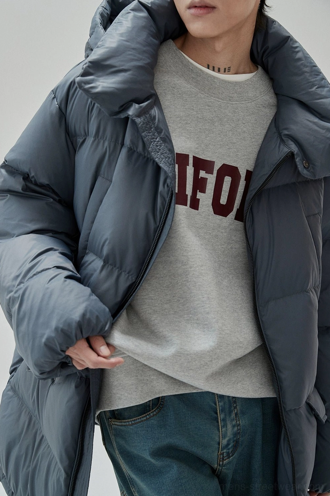 Gray UNIFORM streetwear sweatshirt layered under an oversized dark gray puffer jacket