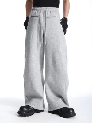 Rear full-body view of solid gray wide-leg sweatpants showing the relaxed loose-leg fit, adjustable drawstring waistband, and clean minimalist streetwear design