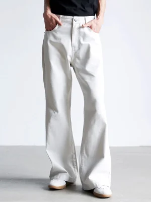 Grayish white wide barrel jeans worn with a black top and white sneakers in a low-angle front streetwear studio view