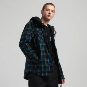 Green and dark teal buffalo plaid hooded snowboard jacket shown from a left three-quarter view with chest flap pockets, adjustable hem, and relaxed outdoor streetwear fit