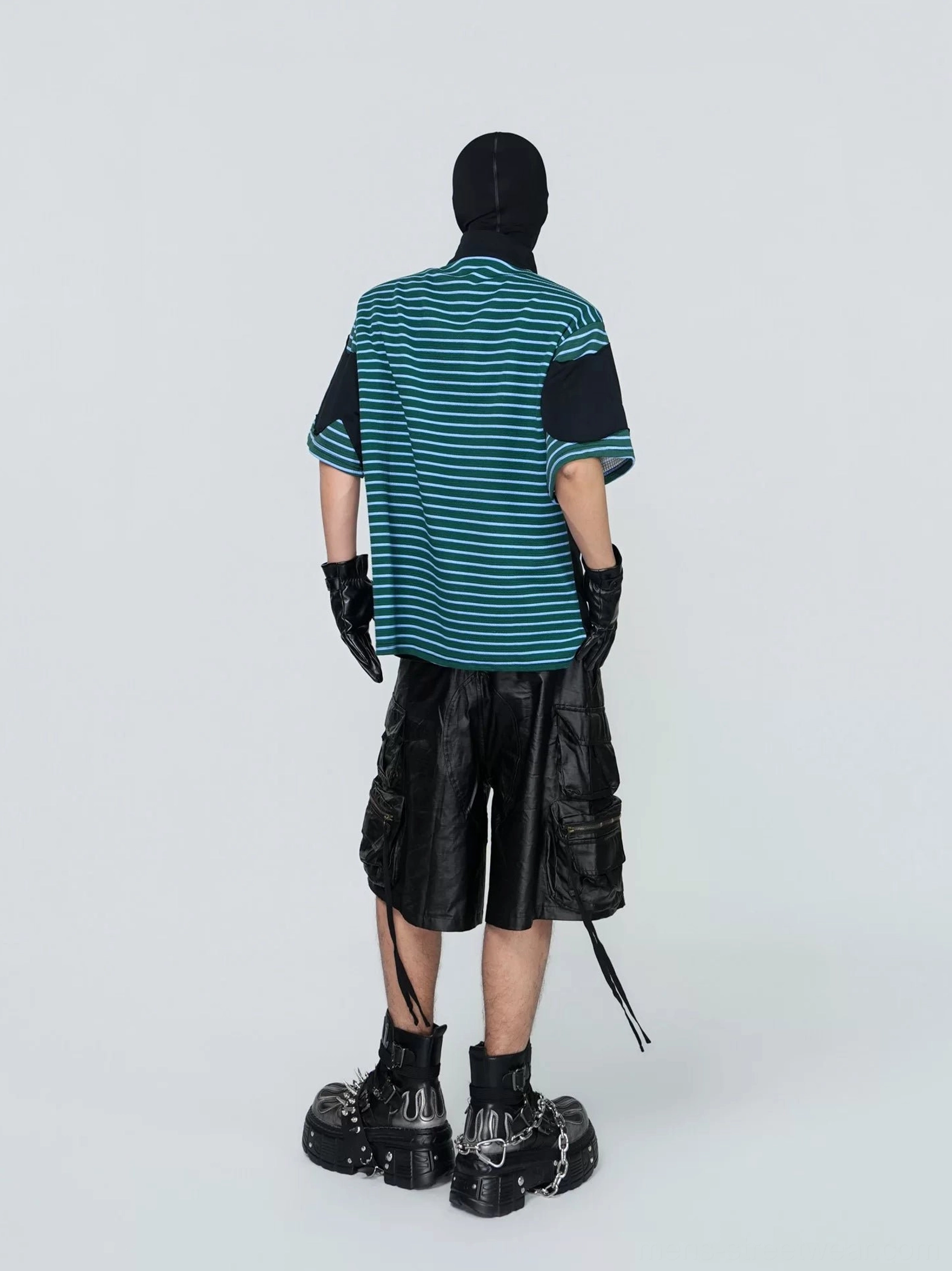Back view of a green and teal striped techwear-inspired streetwear tee with curved horizontal graphic stripes, black short sleeves, and relaxed draped fit