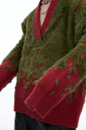 Close-up of soft fuzzy green and wine red gradient knit sweater fabric with contrast ribbed V-neck and cuffs