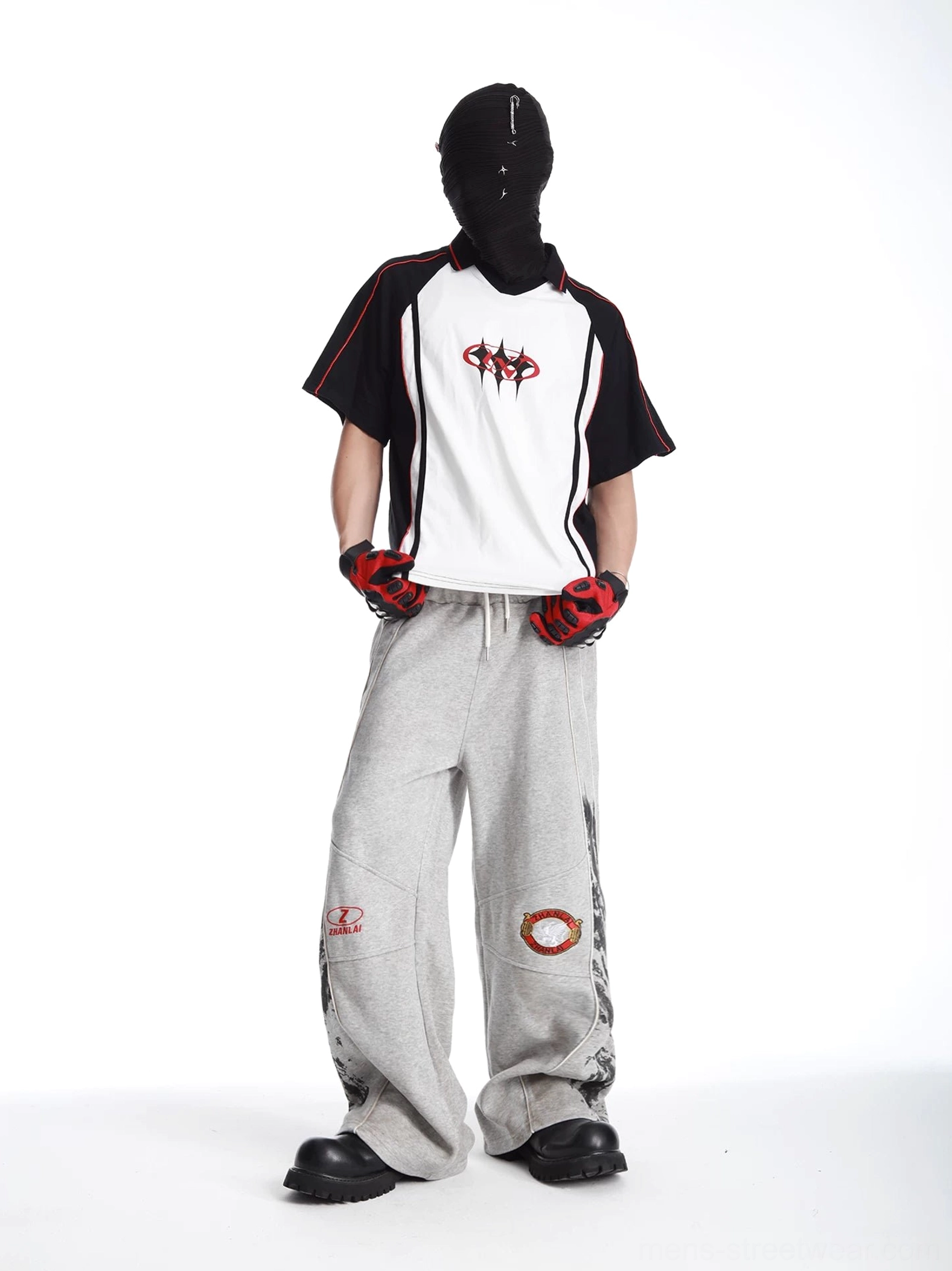 Grey baggy racing streetwear sweatpants front full-body outfit view with red embroidered thigh badges