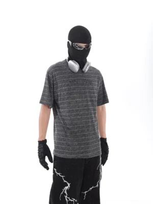 Left side view of a relaxed grey black striped T-shirt showing the oversized streetwear silhouette and lightweight drape