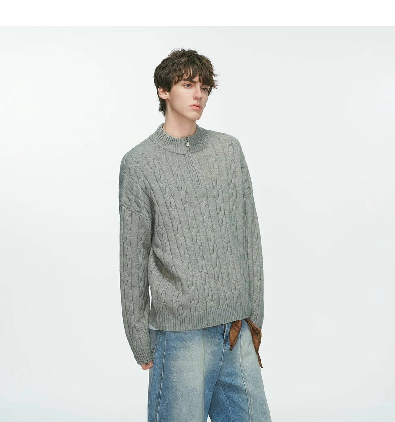 Grey cable-knit half-zip sweater with relaxed oversized fit styled with light wash jeans and a plaid scarf