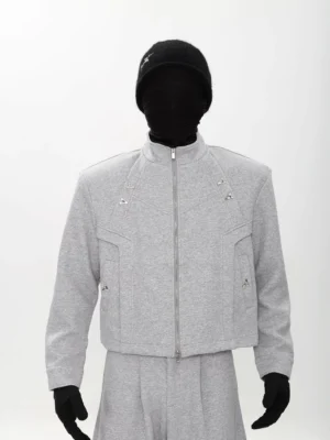 Full-body view of a grey cropped techwear zip jacket and matching wide-leg sweatpants streetwear set with padded shoulders, stand collar, and geometric metal details