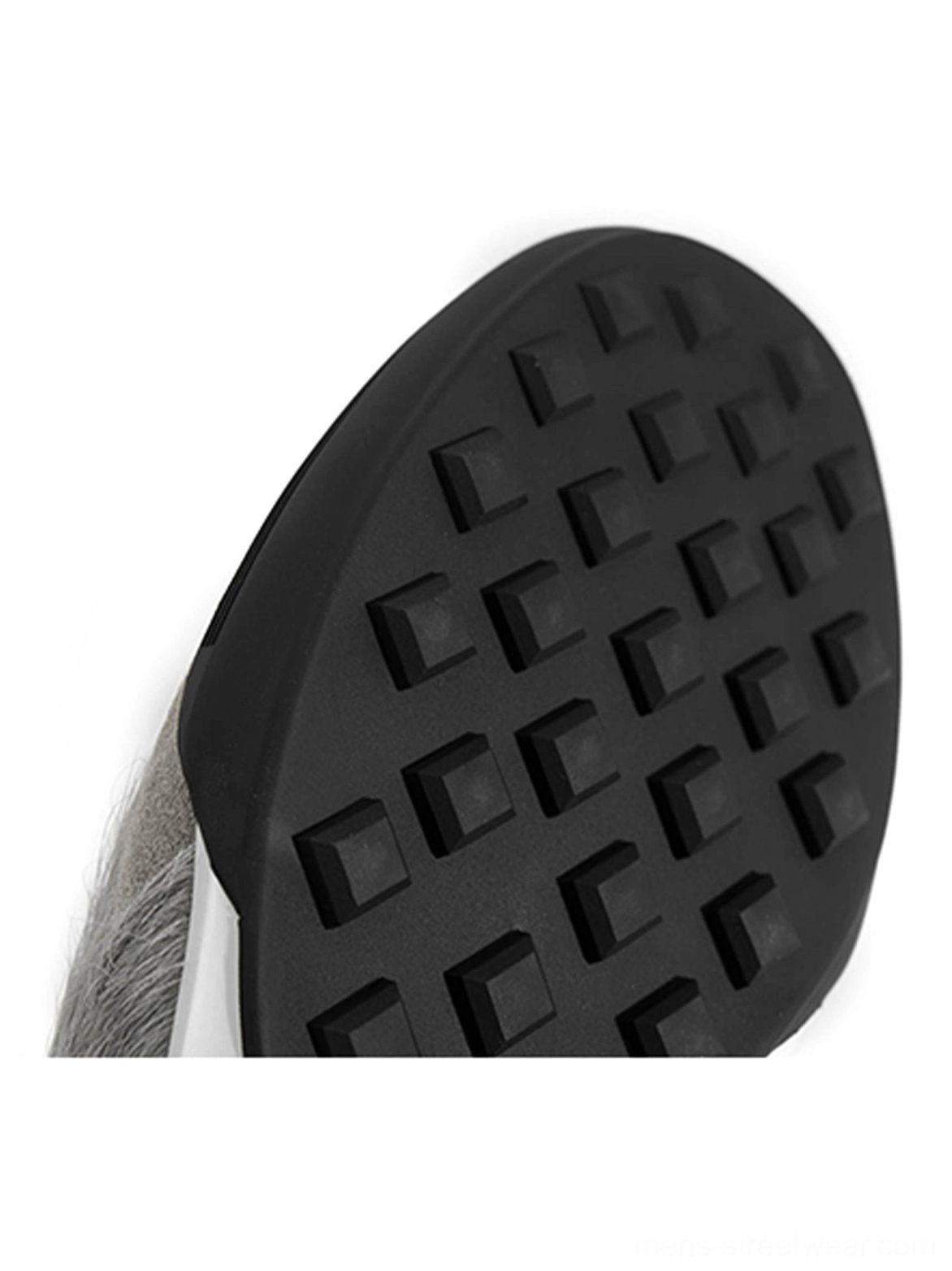 Close-up of the black rubber outsole on grey fur-lined platform sneakers featuring a square-grid traction tread pattern