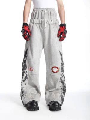 Grey racing graphic wide-leg streetwear sweatpants front view worn with black work boots and racing gloves