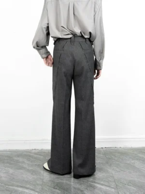 Back view of grey split-hem wide-leg streetwear trousers with belt loops, welt pockets, and side hem slits styled with a light grey shirt