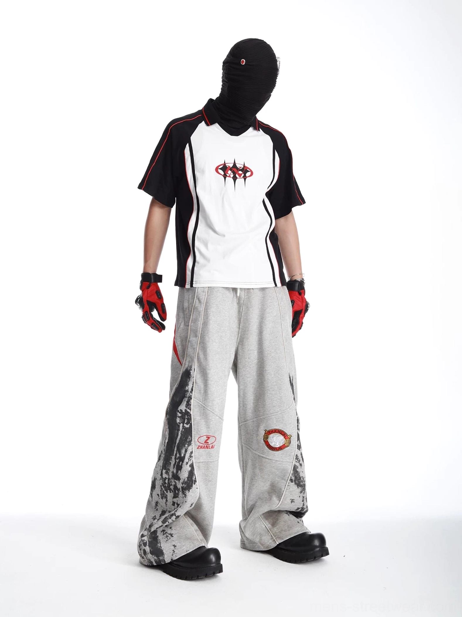 Grey wide-leg graphic sweatpants angled side view featuring red accent panel and motorsport-inspired styling