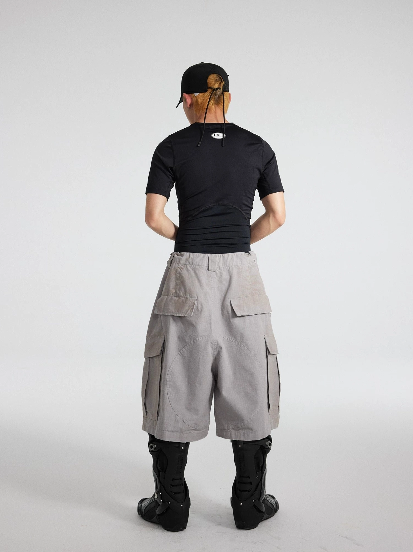 Back view of grey workwear cargo culottes with dual rear cargo pockets, wide cropped silhouette, and moto boots