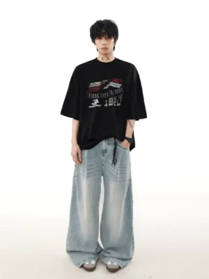 Full-body male model wearing a black oversized racing graphic tee with light-wash baggy jeans in a relaxed streetwear outfit