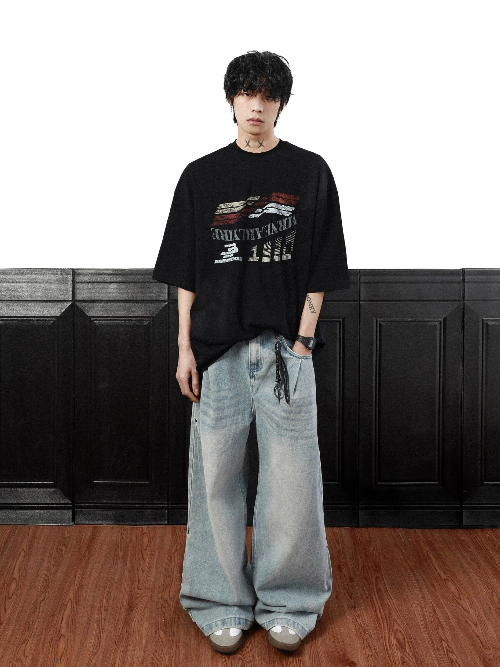 Black oversized streetwear T-shirt with drop shoulder silhouette and distressed retro racing graphic styled with wide-leg denim