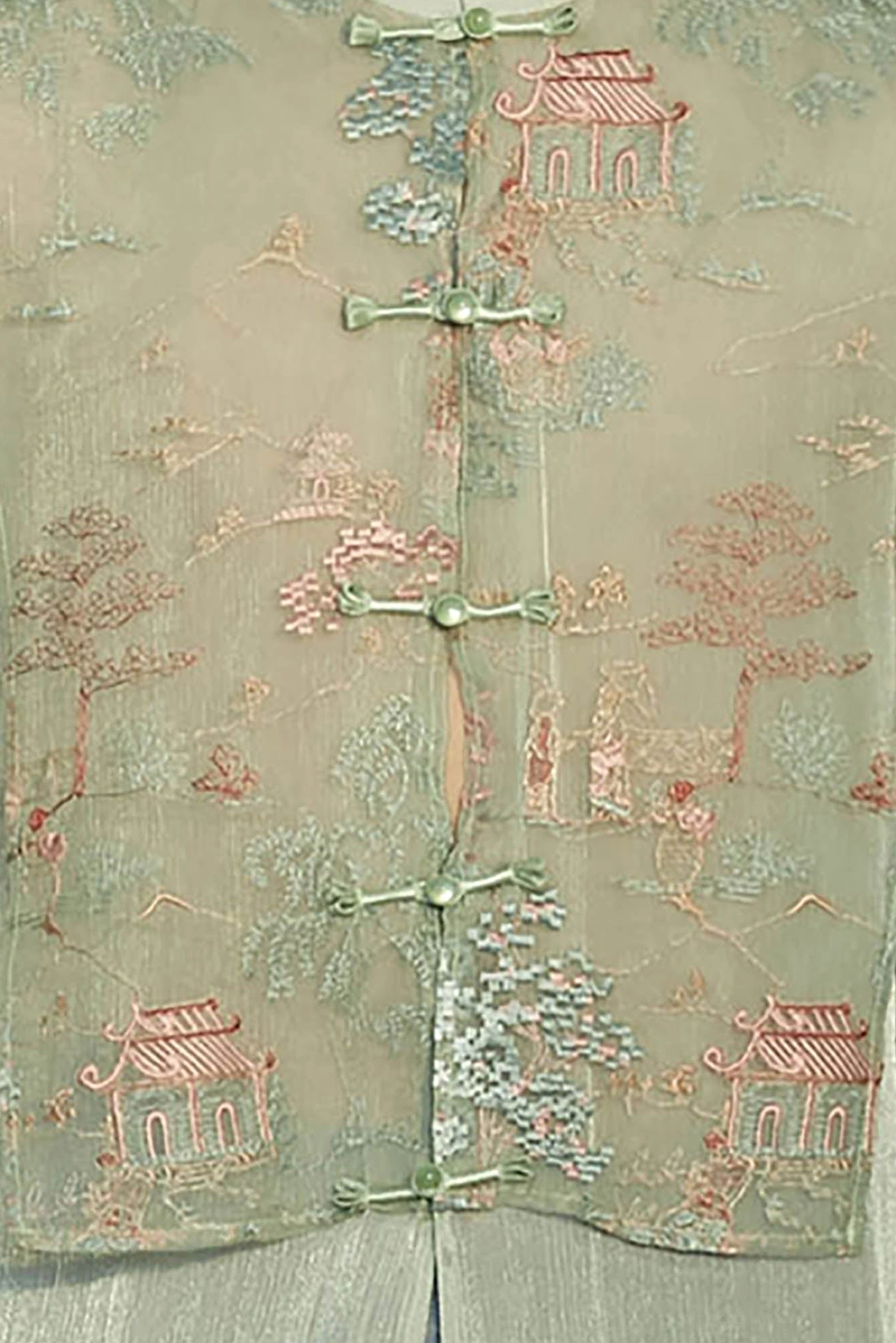 Close up of traditional Chinese landscape embroidery and matching mint frog button closures on Hanfu vest jacket