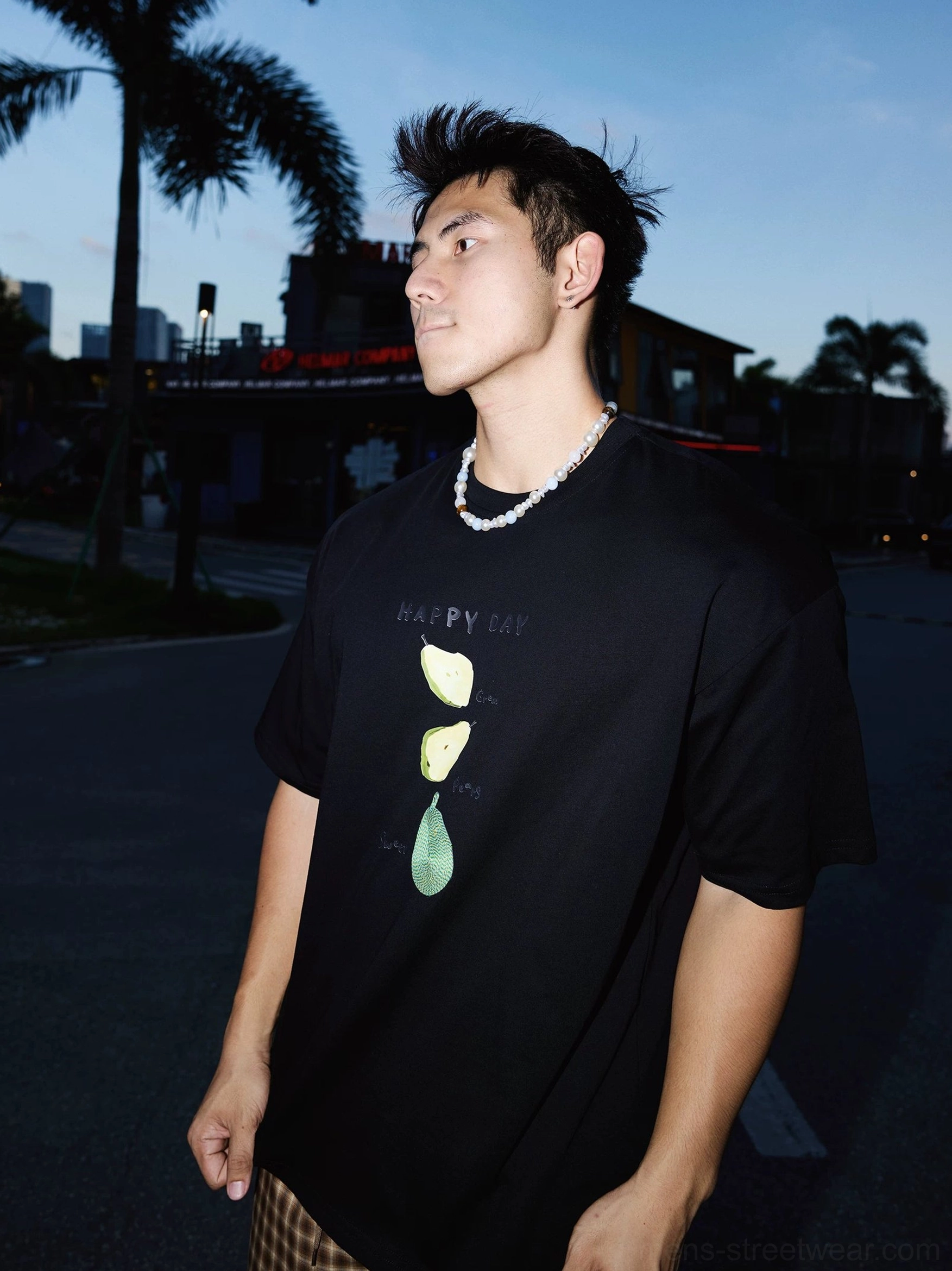 Side front view showing the stacked citrus fruit print and Happy Day lettering on a relaxed Korean style black graphic tee
