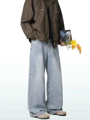 Male model wearing light faded sky-blue wide-leg jeans with a brown cropped leather jacket in a vintage Korean fashion look