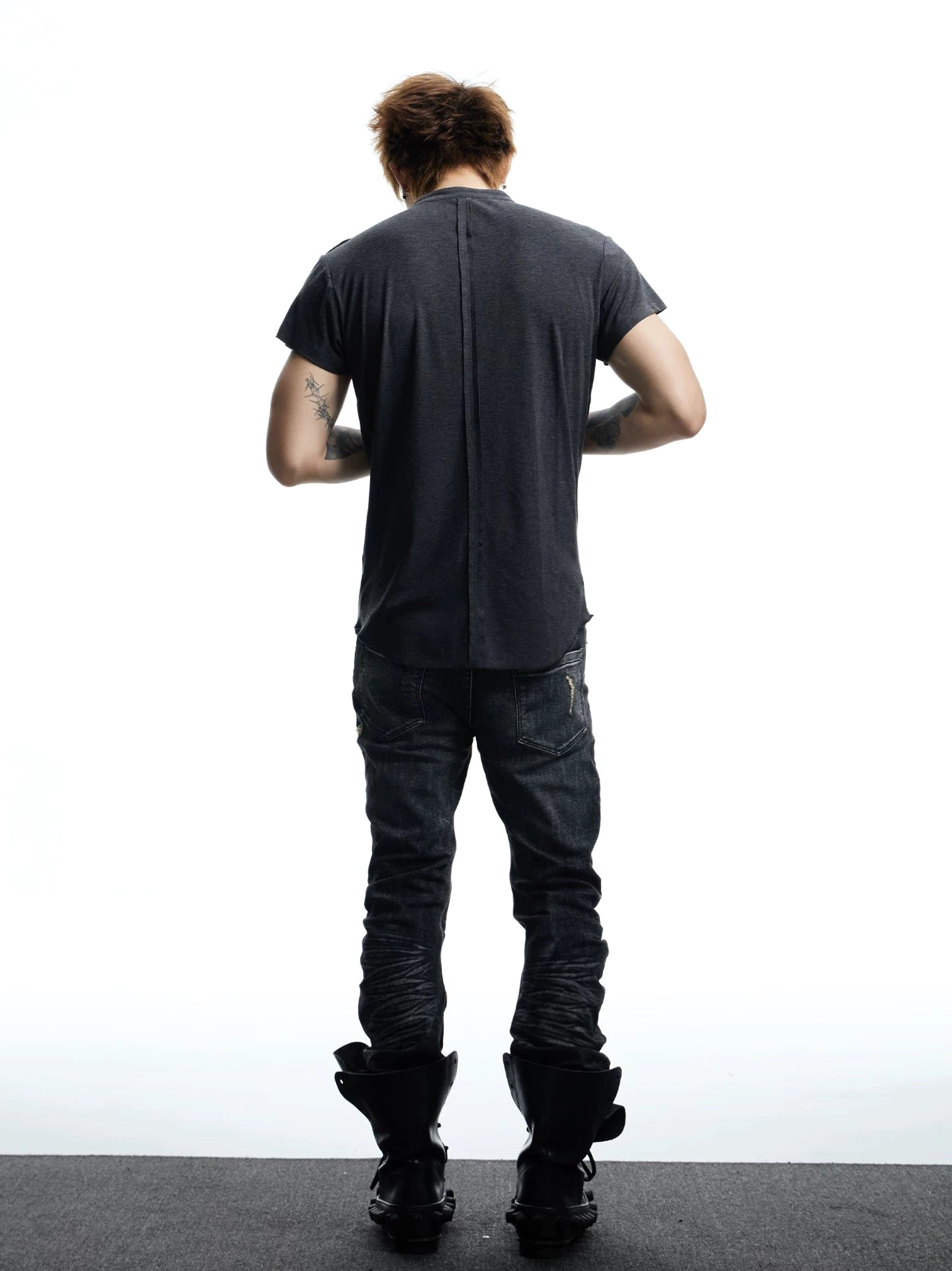 Back view of a men's heather charcoal gray Henley T-shirt featuring a slim silhouette and central back seam in a studio setting