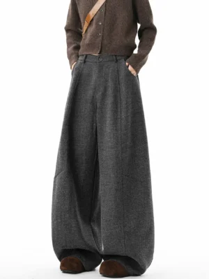 Heather dark gray high-waisted balloon wide-leg tailored trousers shown in a front three-quarter view with pleated waist and oversized draped silhouette