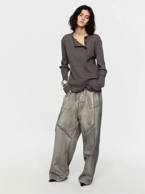 Heather gray slim fit asymmetric Henley ribbed sweater styled with faded wide leg denim in side view