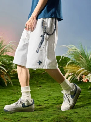 Heather light gray relaxed sweat shorts with dark clover embroidery, twisted rope drawstring, and loose leg opening styled in contemporary Asian streetwear