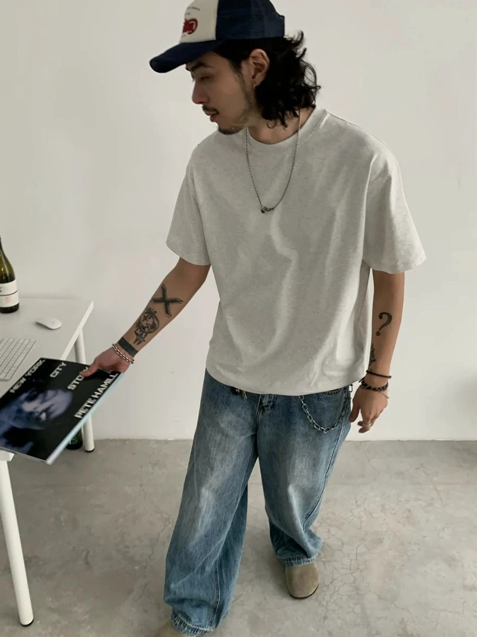 Heather gray loose fit crew neck t-shirt styled with baggy blue jeans and vinyl record for casual streetwear
