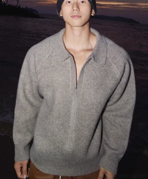 Heather gray oversized half-zip knit sweater with wide collar worn by male model with brown trousers and black beanie in seaside sunset streetwear look