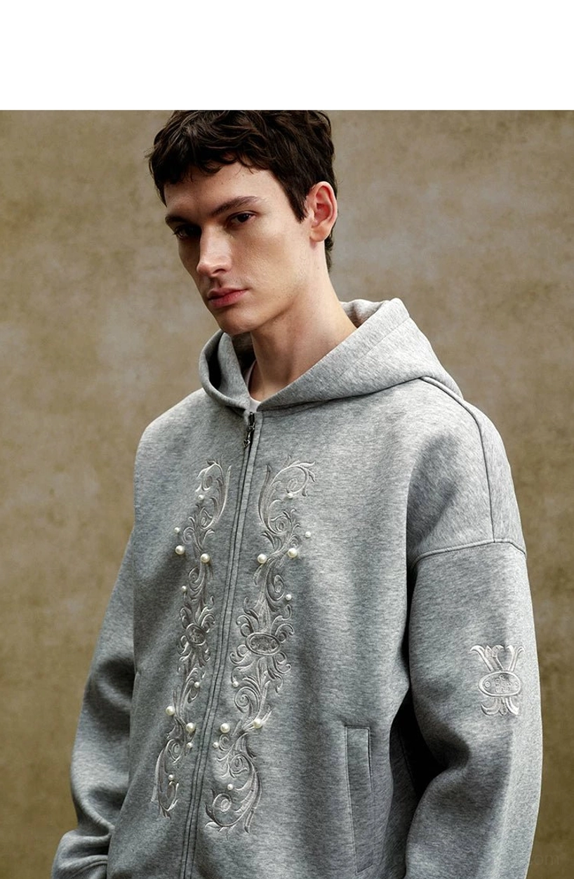 Close-up of heather gray zip-up hoodie featuring ornate floral scroll embroidery pearl-like embellishments and zipper detail
