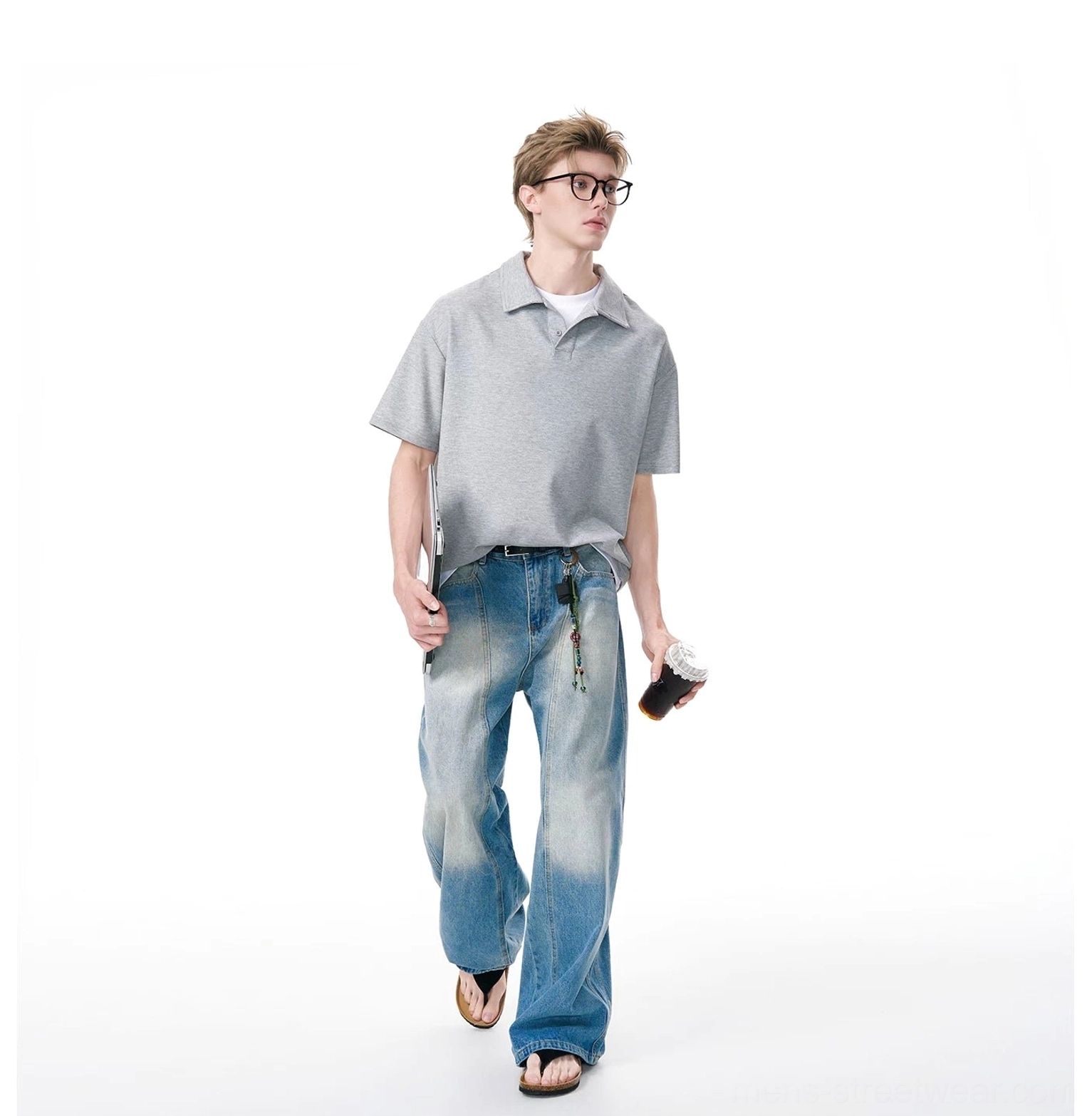 Side view of a heather gray relaxed knit polo shirt with curved hem, wide-leg blue jeans, and layered T-shirt