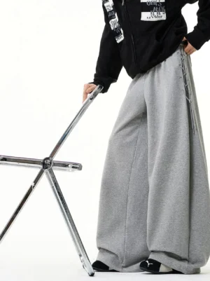 Heather gray side-lace wide-leg sweatpants shown from a low three-quarter angle with oversized Korean streetwear styling and elastic waistband