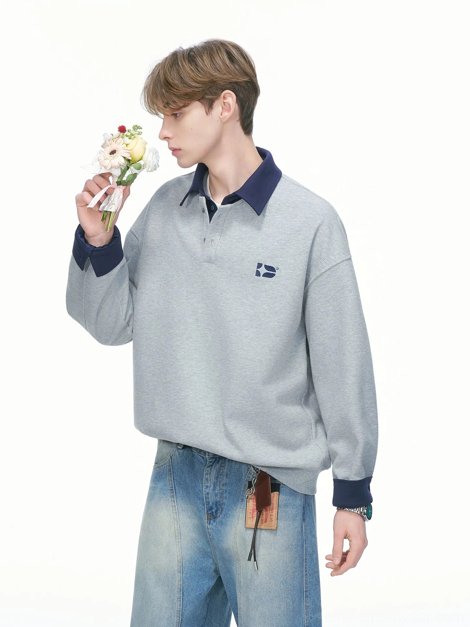 Heather gray varsity rugby sweatshirt shown from the side with contrast navy collar cuffs quarter-button neckline and embroidered chest badge