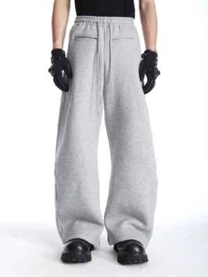 Front full-body view of heather gray wide-leg sweatpants with elastic drawstring waist, front slash pockets, relaxed Korean streetwear silhouette, and chunky black boots
