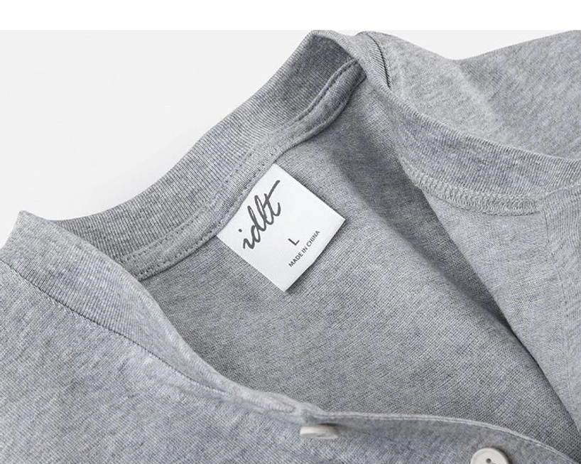 Inside collar detail of heather grey cotton Henley T-shirt with ribbed neckline construction and size tag