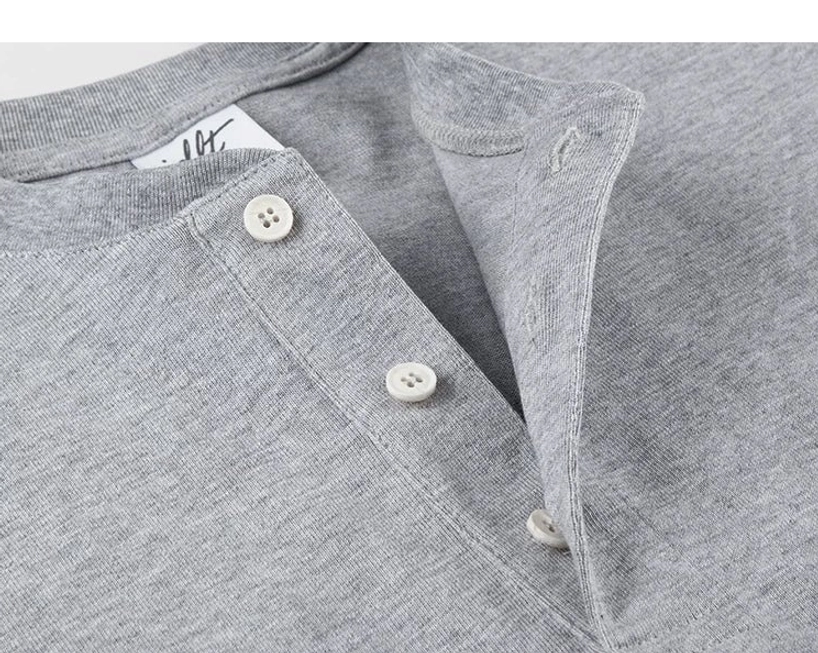 Heather grey Henley T-shirt collar and placket close-up with three off-white buttons and precise stitching
