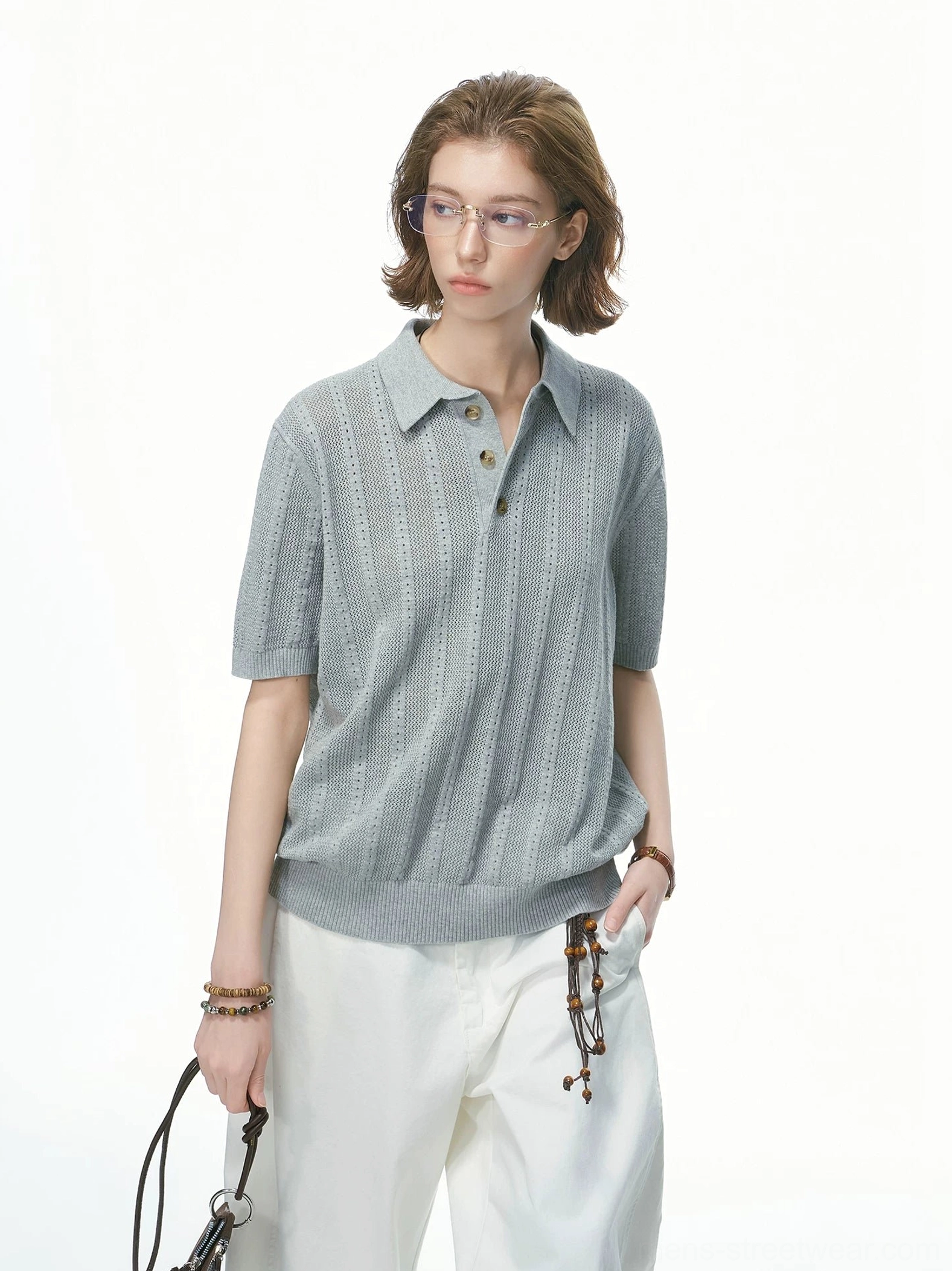 Heather grey pointelle knit polo shirt with button collar styled with white wide-leg trousers and leather handbag
