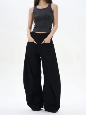 Black high-waisted wide-leg palazzo pants styled with a grey tank top in a minimalist studio, showing the ultra-relaxed Korean streetwear silhouette